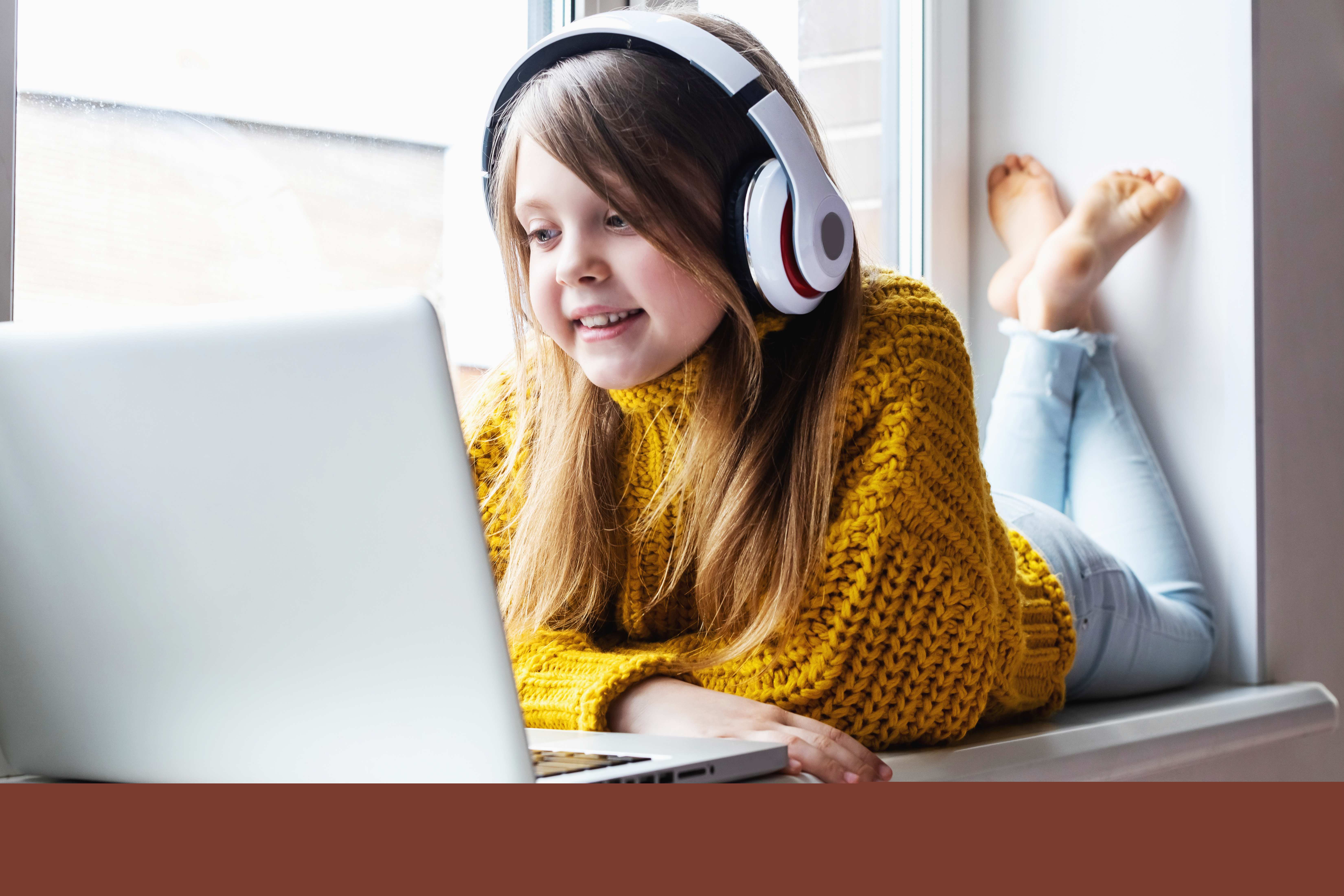 Child girl using laptop wearing headphones.jpg