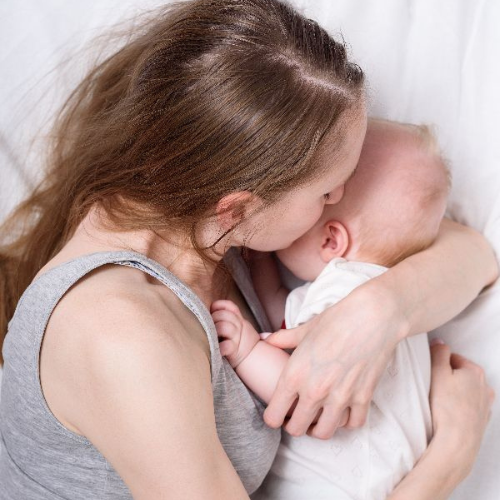 Mother and Baby laying on a bed.jpg